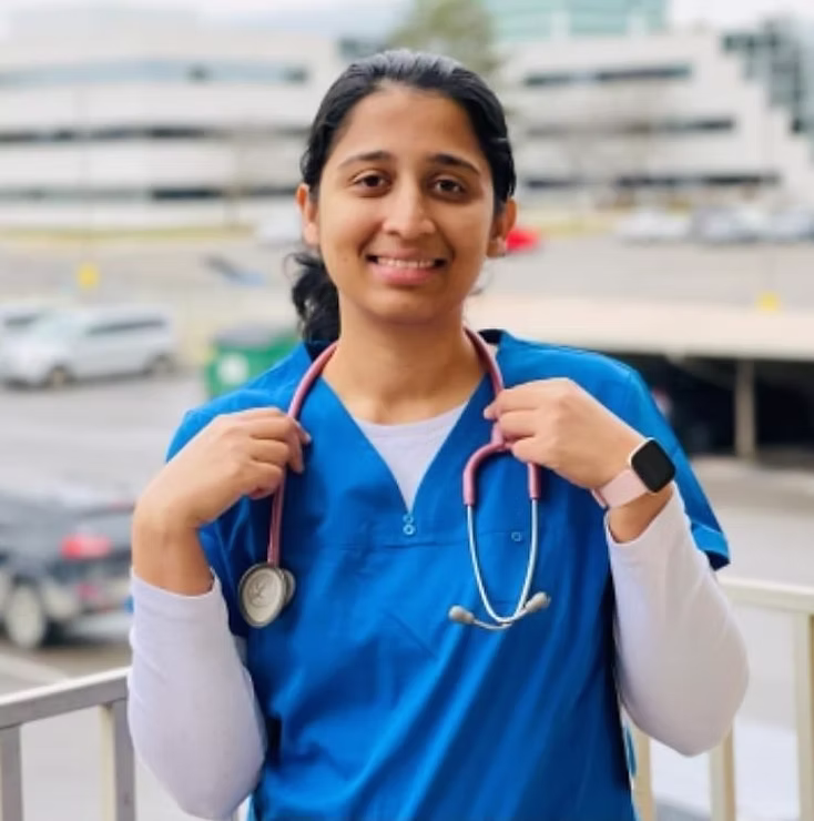 Nurse in blue scrubs smiling