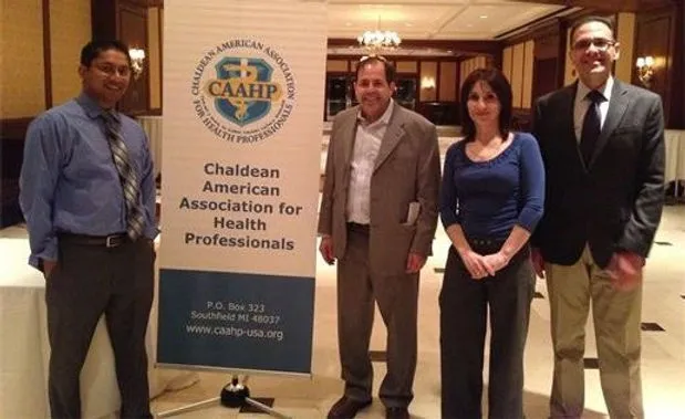 Group standing by health association banner
