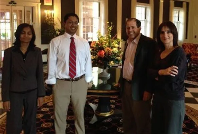 Four people standing in a decorated room.
